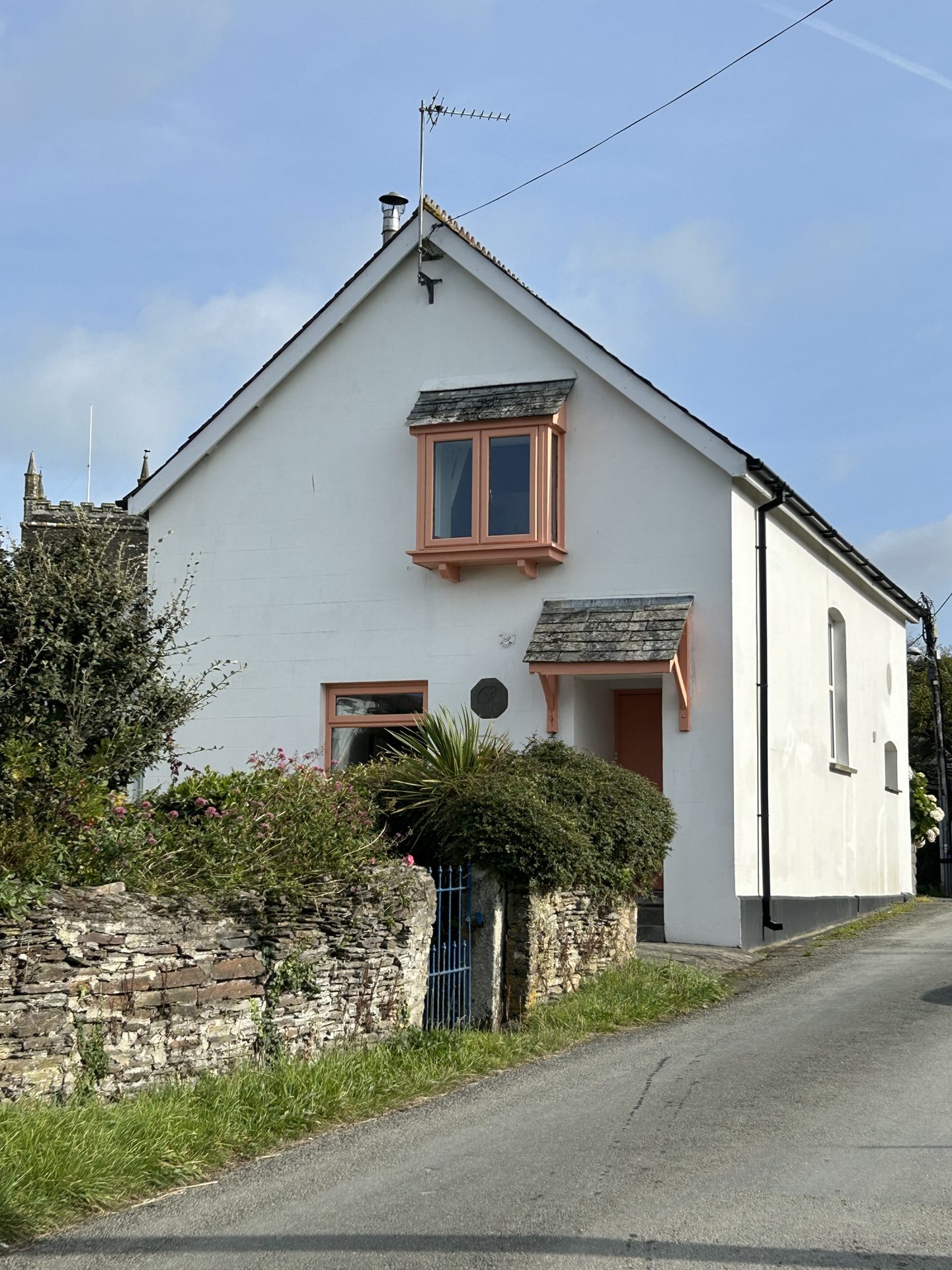 Providence Chapel, a whitewashed former chapel with terracotta window frames, seen from the lane