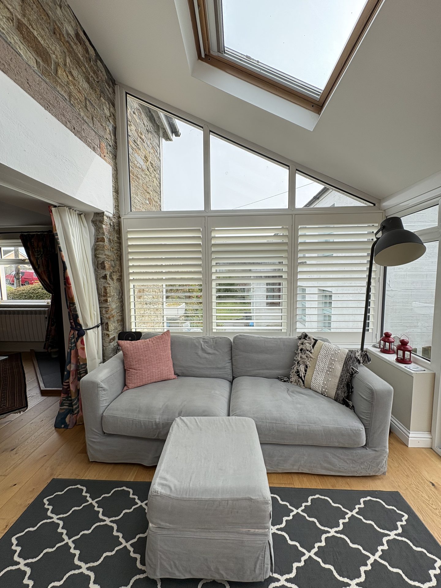 Living room with grey sofa and exposed stone wall